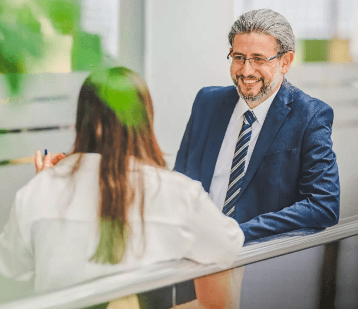 Guven Bircan with colleagues in a workplace setting (faces blurred)